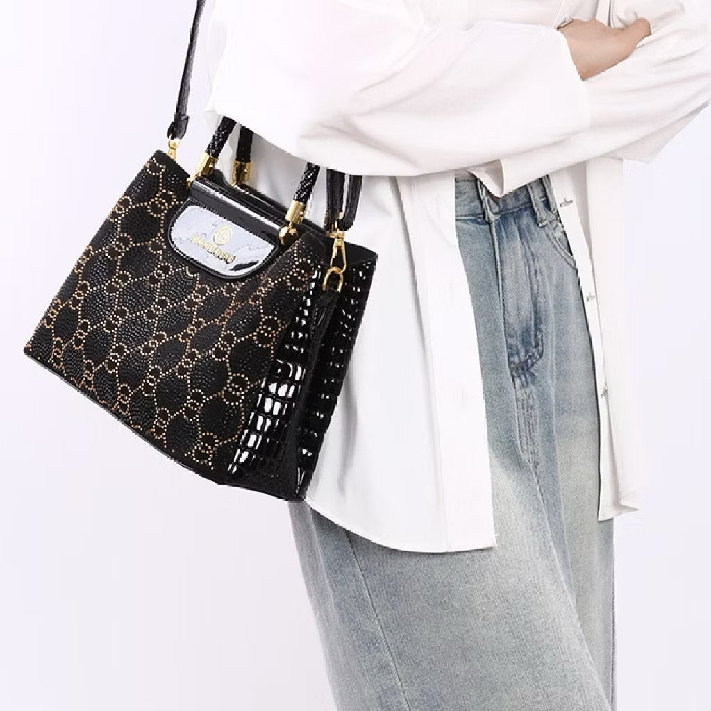 Geometric studded crossbody bag in black with silver accents, featuring a structured design and adjustable strap.