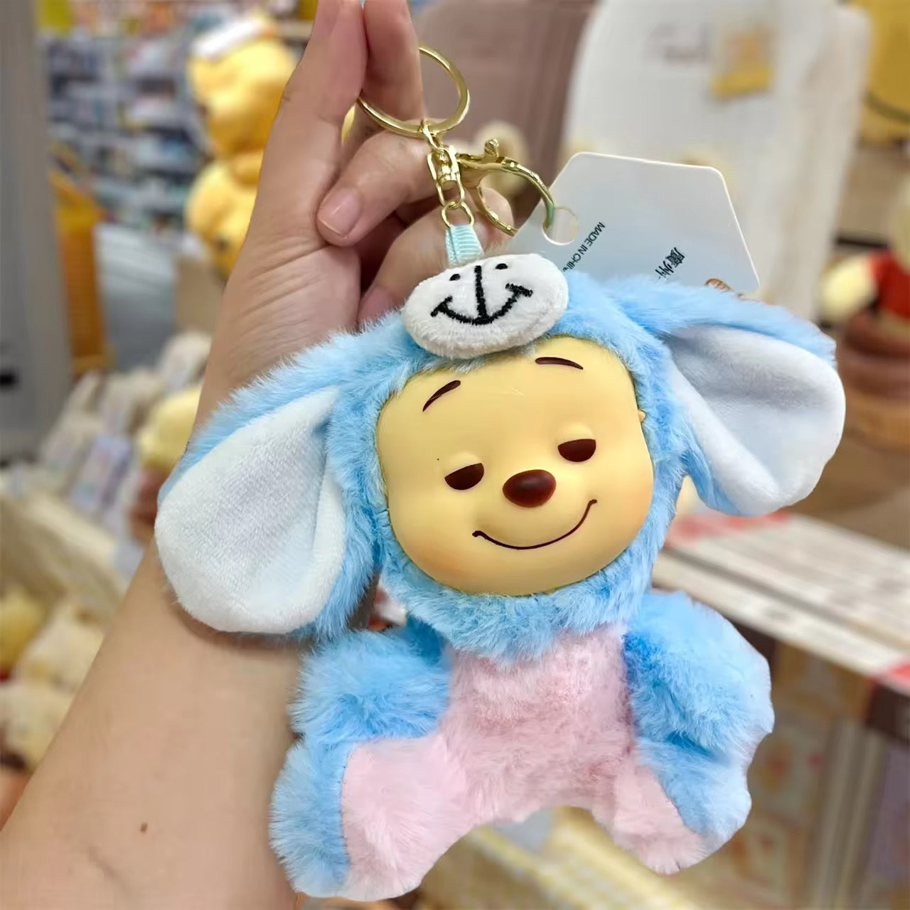 Winnie the Pooh keychain featuring a plush cartoon character with a metal keyring, perfect for bags or keys.