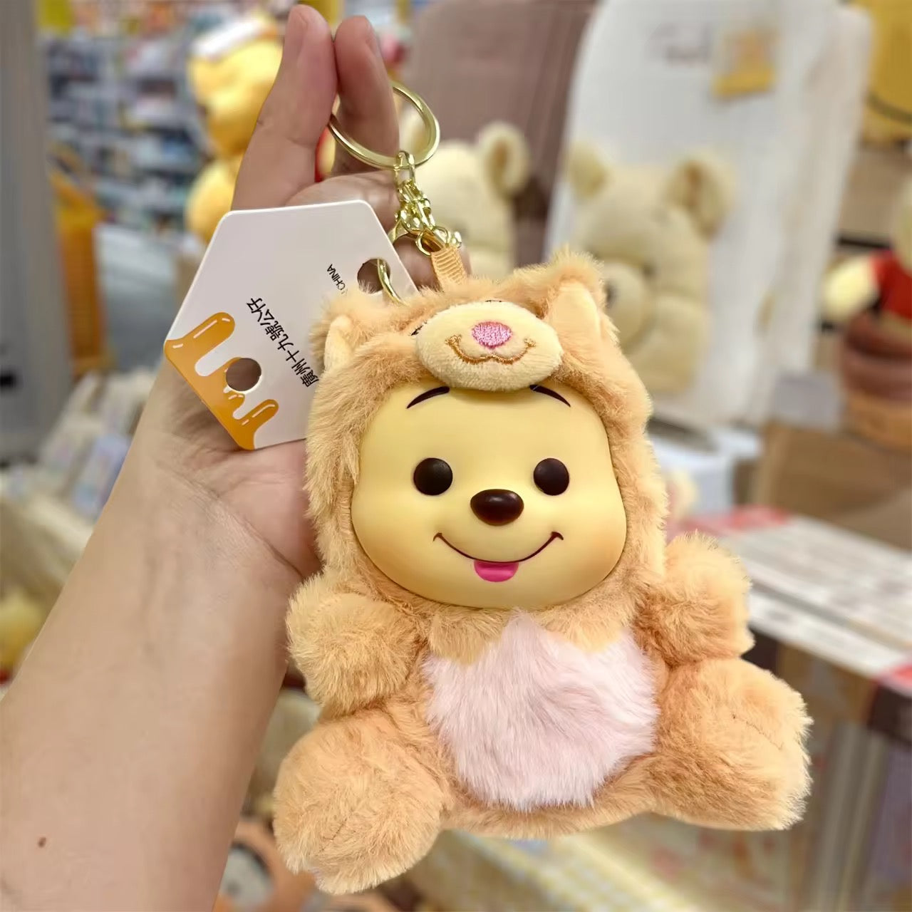 Winnie the Pooh keychain featuring a cute plush figure with a red shirt, attached to a metal keyring.